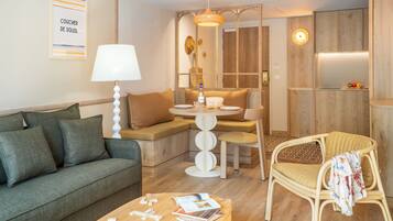 Un salon moderne comprenant un canapé, une table à manger, une chaise et une lampe.