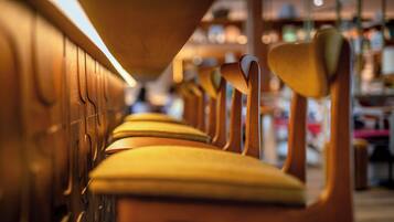 A row of wooden chairs with yellow cushions in a well-lit indoor setting.