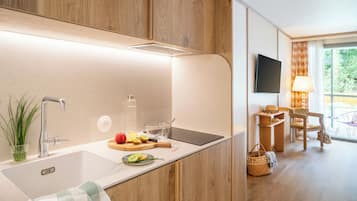 A modern kitchen with a wooden cabinet, a stainless steel sink, and a cutting board with fruits.