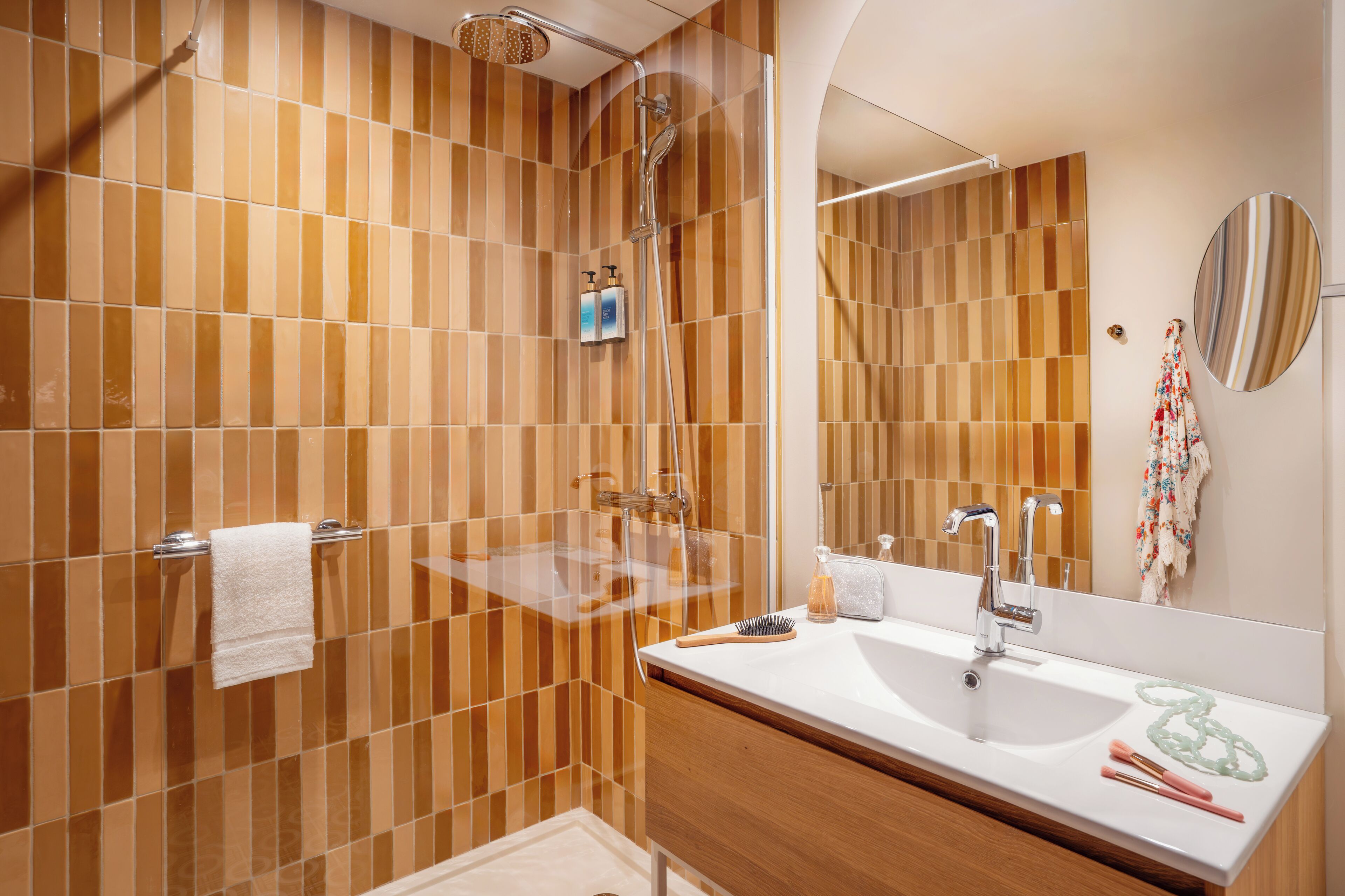 Un baño moderno con ducha, lavabo y espejo.