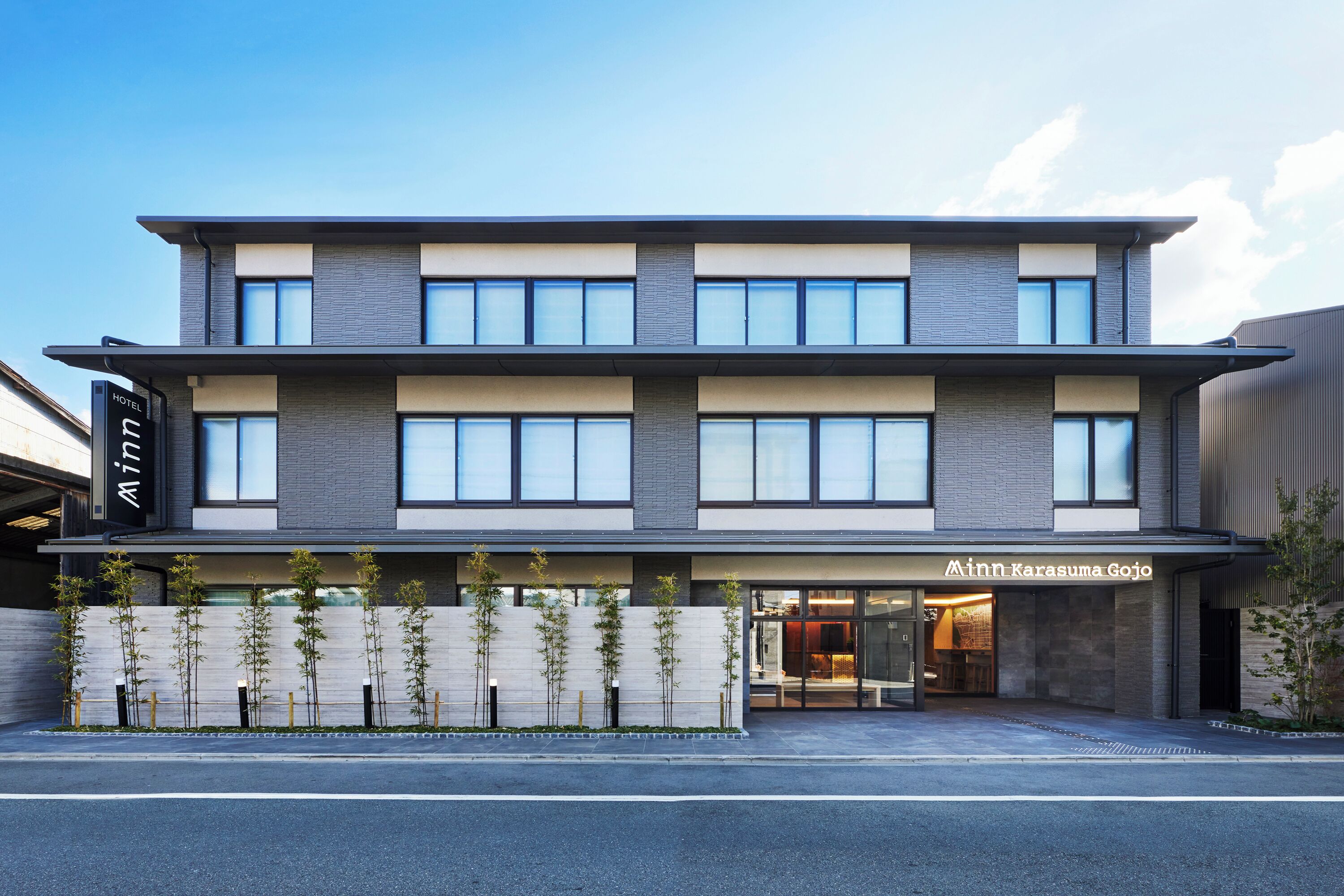 A modern hotel with a two-story structure, a visible entrance, and a sign indicating it is a hotel.