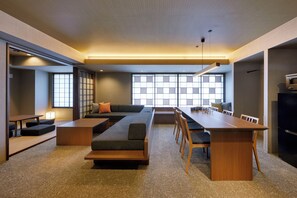 A modern living room with a sofa, a dining table, and chairs. There is a large window with a view of the outside. - Minn Karasuma Gojo Kyoto Station (Kyoto)