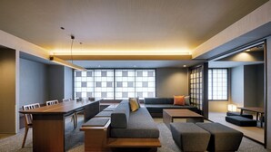 Una sala de reuniones moderna con una mesa larga, sofás y un gran ventanal con vistas.