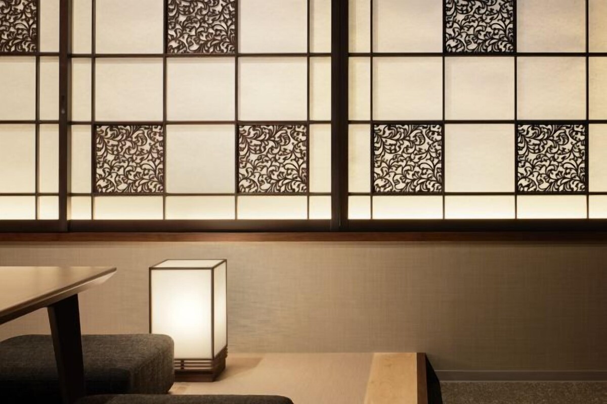 A room with a traditional Japanese-style shoji screen, a low table, and a floor lamp.