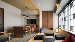 Un interior moderno con comedor, asientos y un ventanal con detalles decorativos.