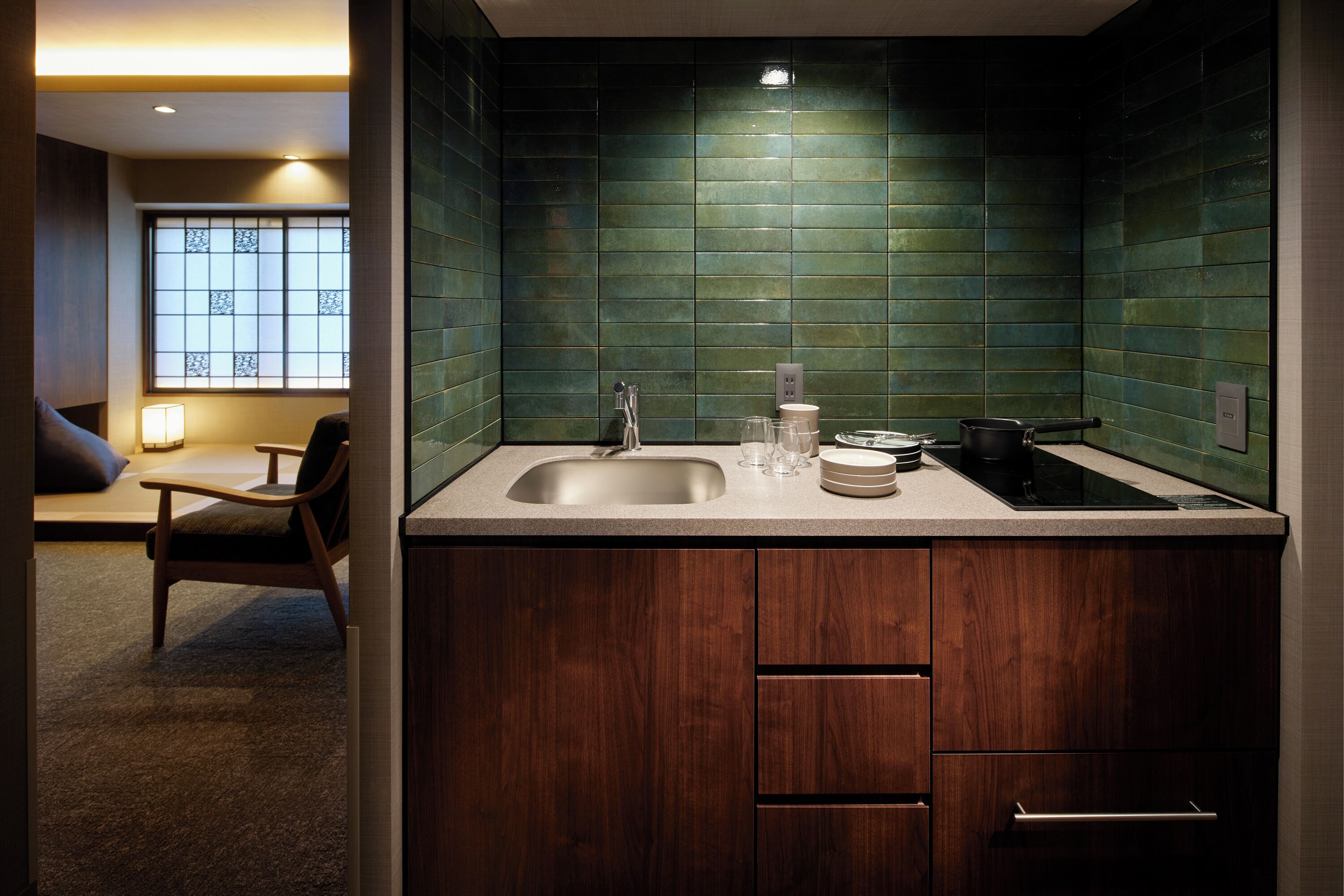 A modern kitchen with a sink, countertop, and wooden cabinets.