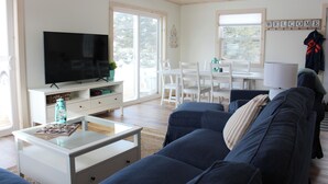 A modern living room with a flat-screen TV, white furniture, and a 'WELCOME' sign. - Newly Built Ocean View Cottage, Minutes To Thunder Cove Beach (Kensington)