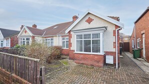 A residential house with a brick facade, a large front window, and a small porch area. - Host & Stay | Wardman Crescent (Redcar)