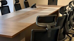 A conference room with a long table and black chairs. - Jadeel Hotel (Al Khobar)