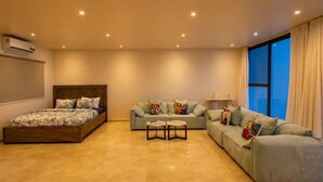 A spacious living area with a bed, a sofa, and a coffee table.