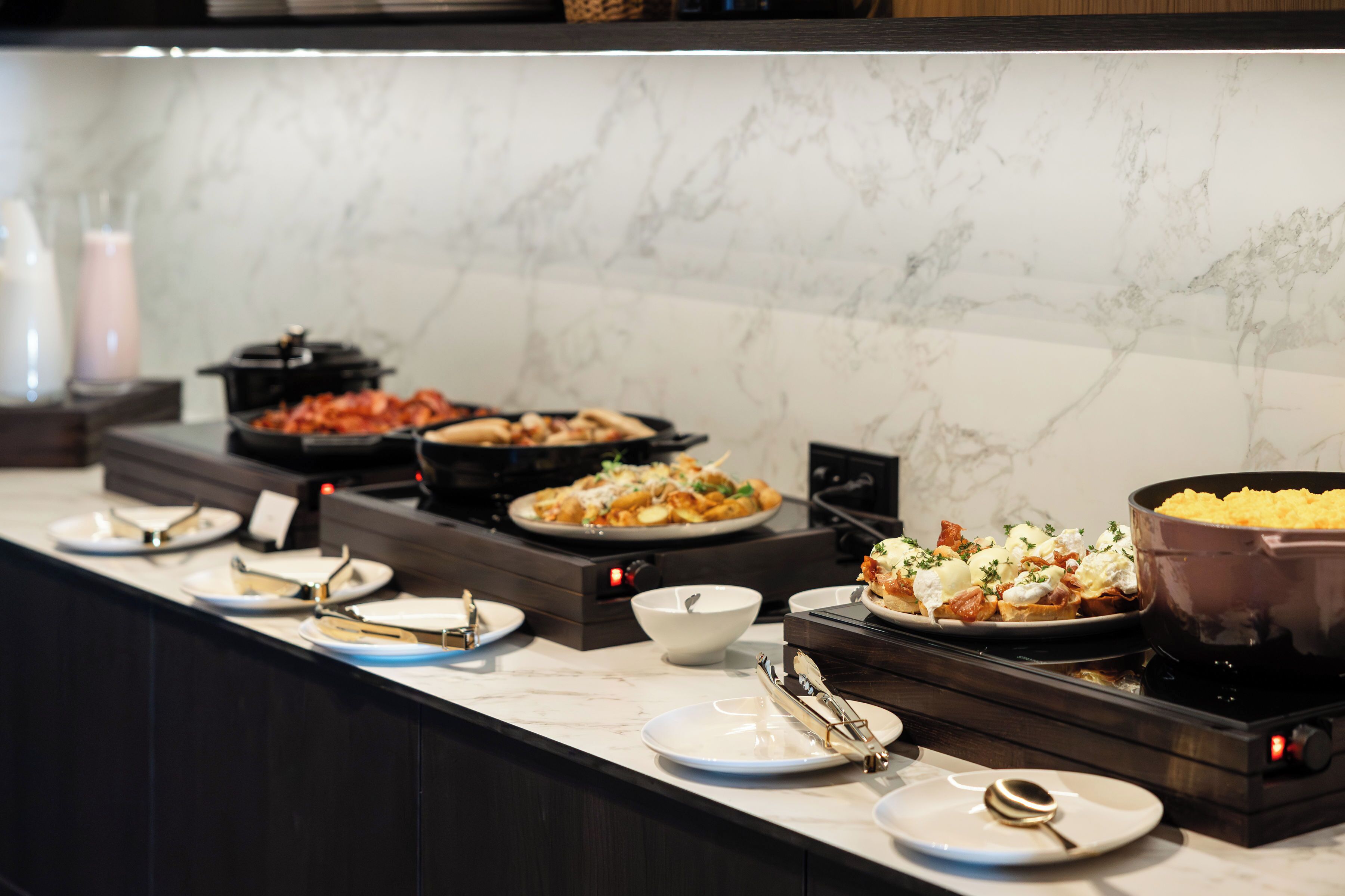 Ein reichhaltiges Buffet mit verschiedenen Speisen und einer Selbstbedienungsstation.