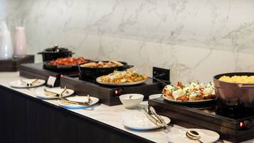 Ein reichhaltiges Buffet mit verschiedenen Speisen und einer Selbstbedienungsstation.