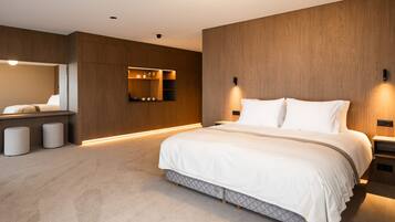Un dormitorio moderno con una cama grande, mesitas de noche, un armario empotrado y un espejo.