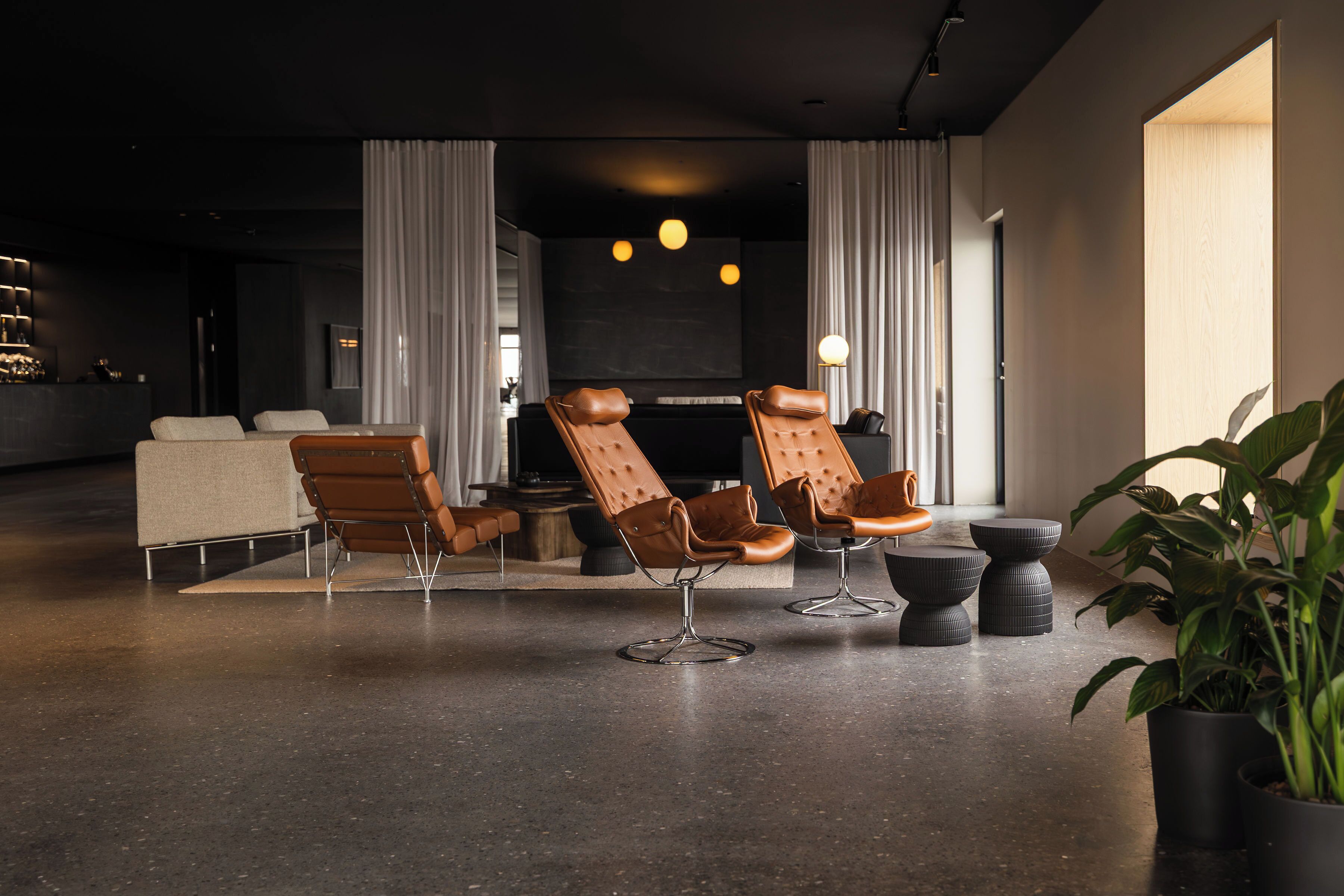 A modern lounge area with leather chairs, a sofa, and a coffee table.