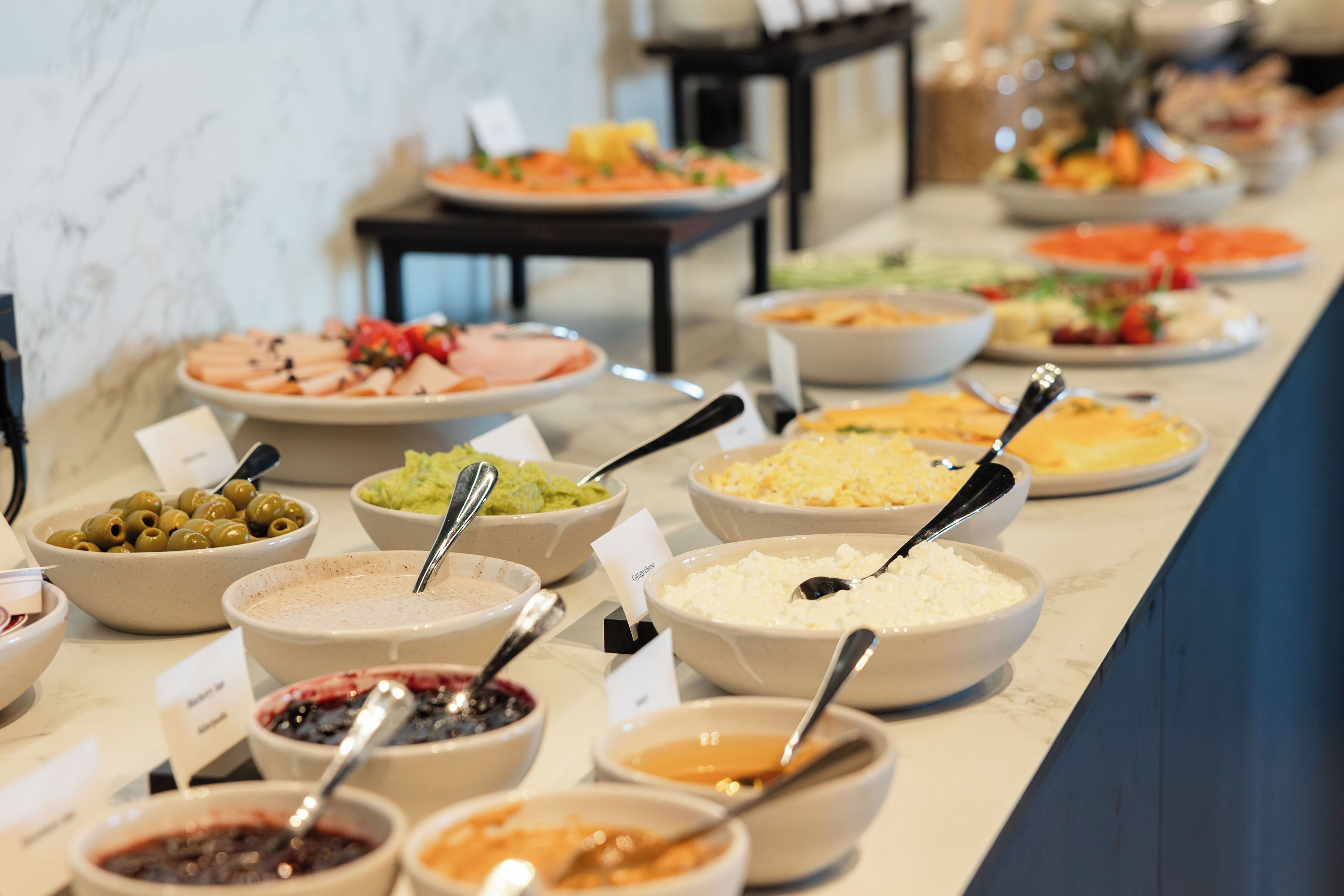 A buffet with various dishes and a marble countertop.