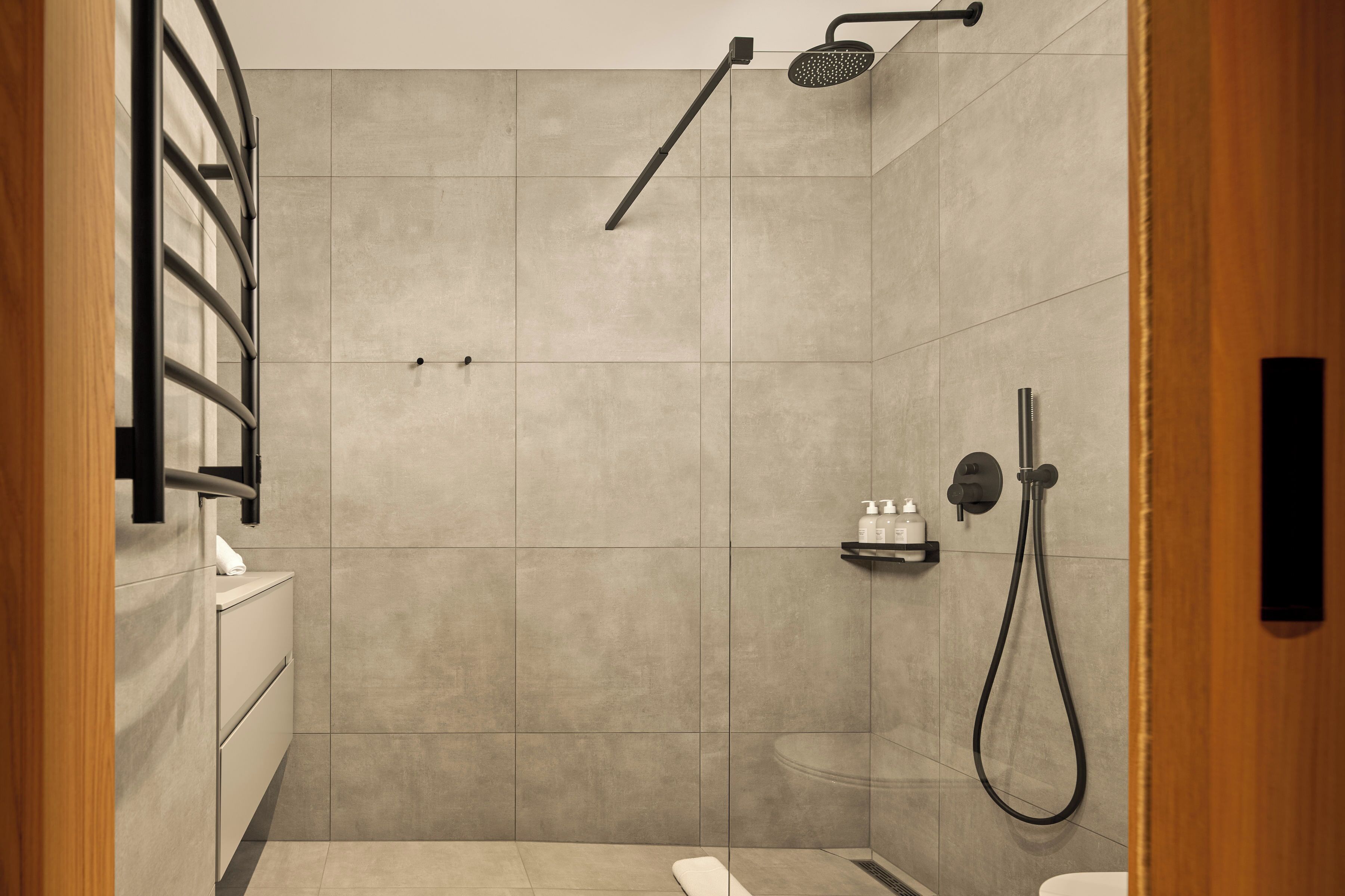 Ein modernes Badezimmer mit Dusche, Toilette und Handtuchhalter.
