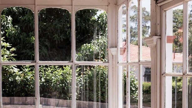 A cozy room with a white sofa, large windows, and a view of greenery outside. - 'Sobrina' - A home away from home in Sandy Bay (Sandy Bay)