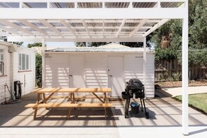 A covered patio area with a wooden picnic table and a barbecue grill. - 'Sobrina' - A home away from home in Sandy Bay (Sandy Bay)