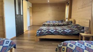 Ein Zimmer mit Holzwänden, einem Bett, einer Bank und einer Tür.