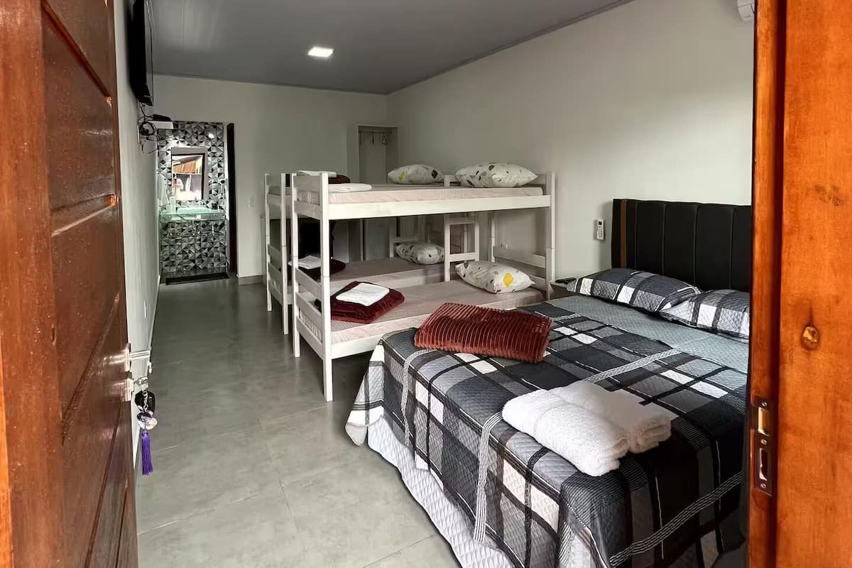 A room with bunk beds, a television, and a small table.