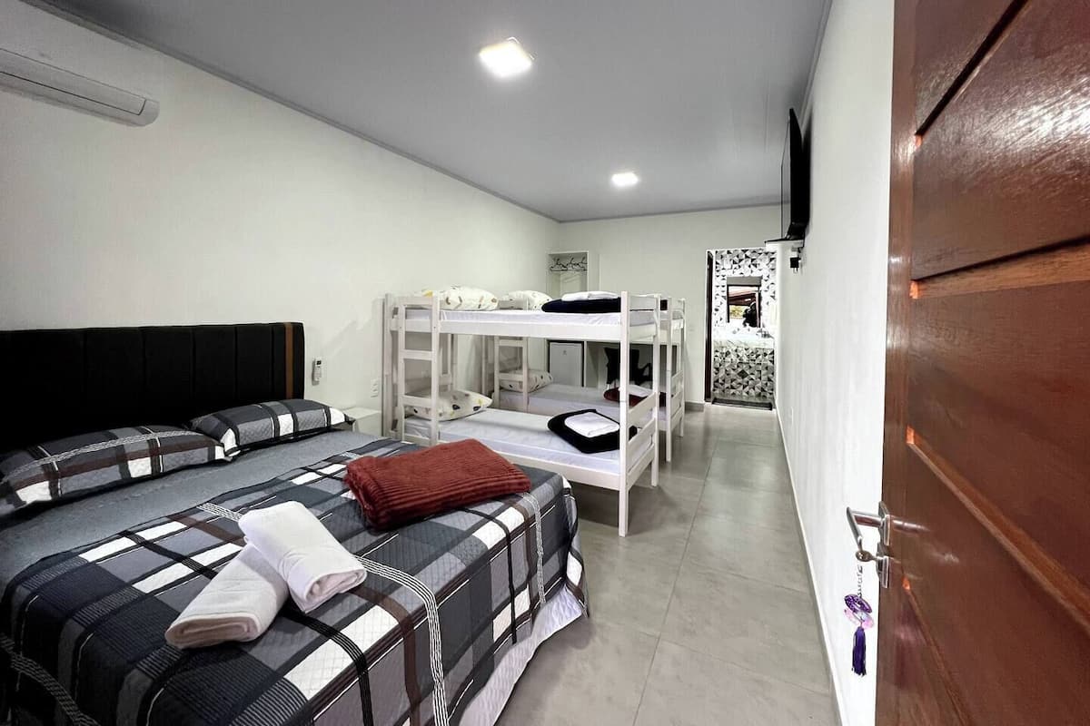 A room with bunk beds, a sofa, and a wooden door.