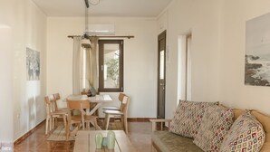 Un comedor con una mesa y sillas, un sofá y un cuadro en la pared.