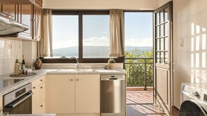 Una cocina moderna con un amplio ventanal, lavavajillas y vistas a las montañas.