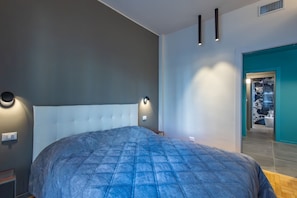 A modern bedroom with a large bed, a nightstand, and a wall-mounted light fixture. - Sanremo Belle Epoque Apartment by Wonderful Italy (Sanremo)