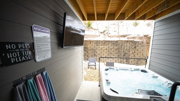 A hot tub area with safety rules, a no pets sign, and a relaxation sign.