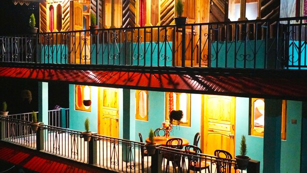 A two-story building with balconies, wooden railings, and potted plants. - Home in the lap of nature 
In a peaceful location..... Darjeeling (WB)