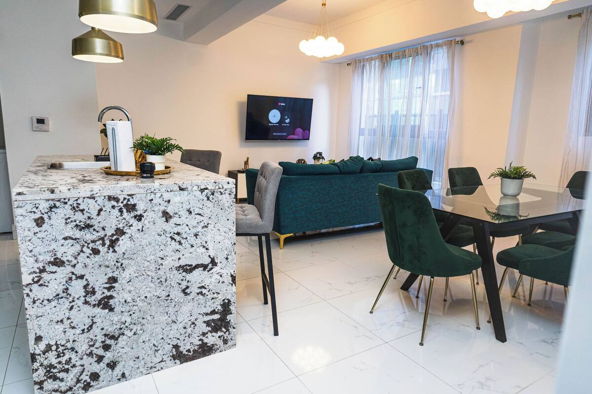 Un espacio habitable moderno con isla de cocina, comedor y sofá.