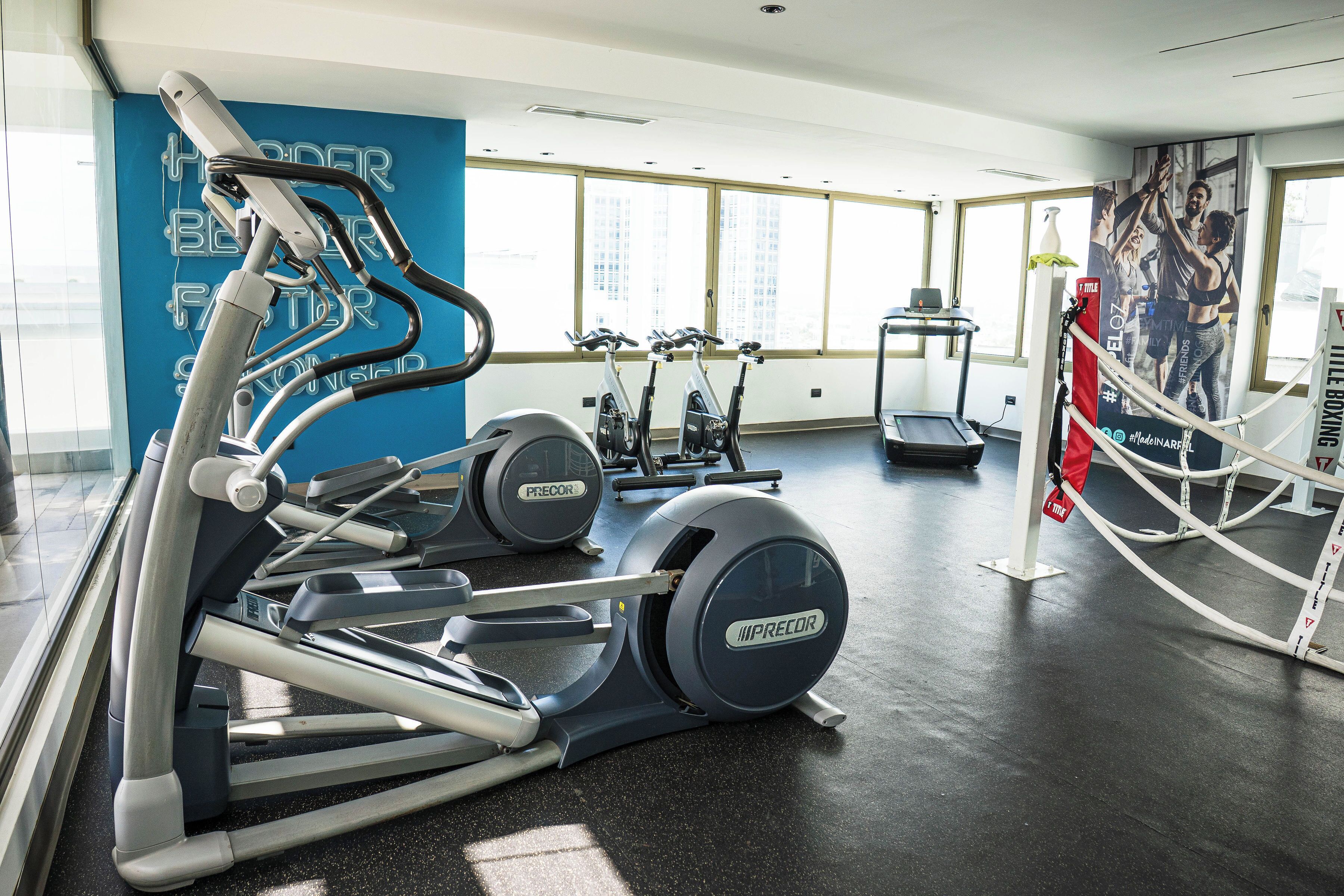 A gym with treadmills, stationary bikes, and a punching bag.
