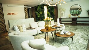 A modern living room with a sectional sofa, a round coffee table, and a decorative vase with flowers. - Arpel 07 - Piantini - Santo Domingo (Santo Domingo)