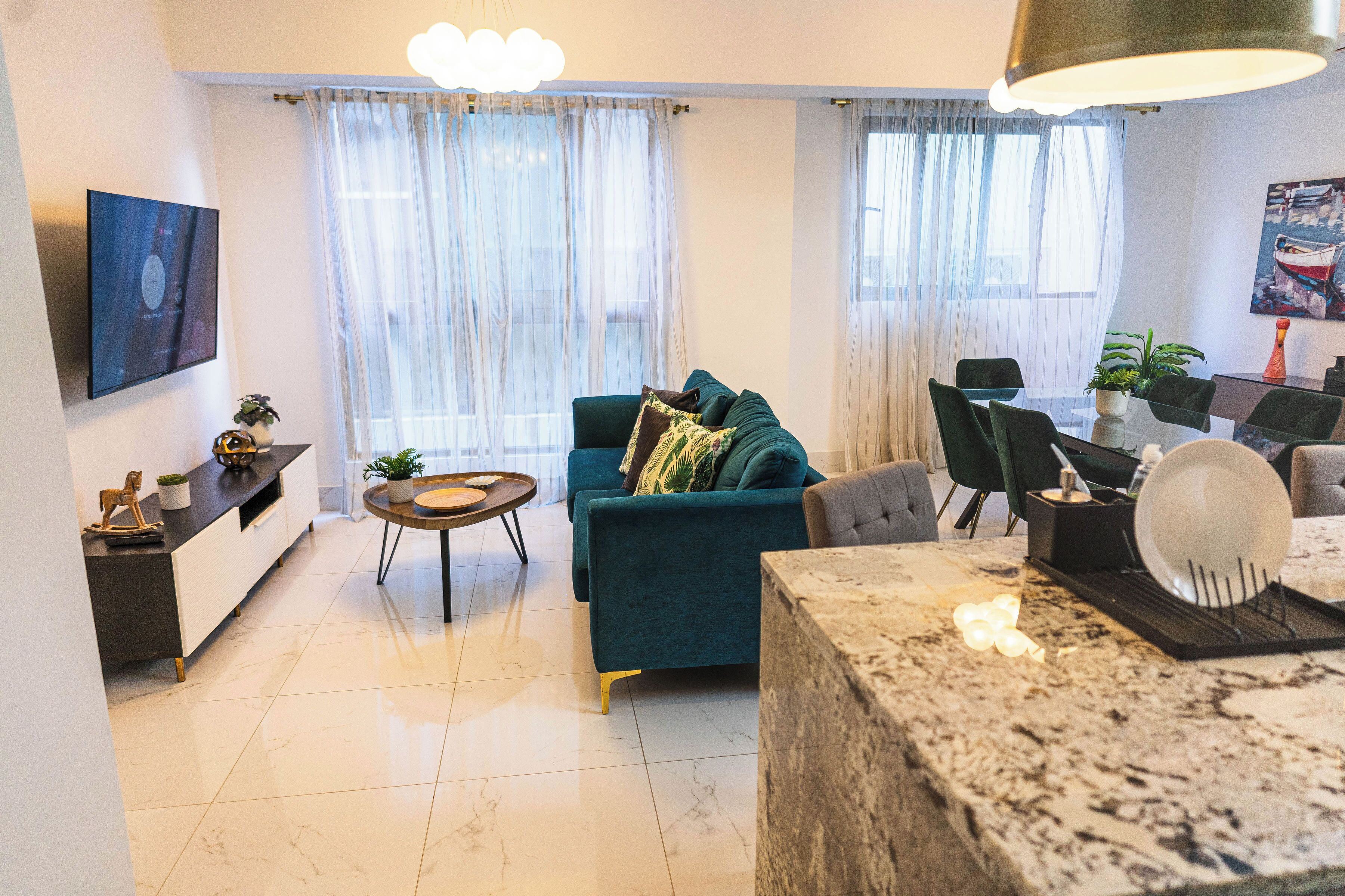Una sala de estar moderna con sofá, mesa de centro y comedor.