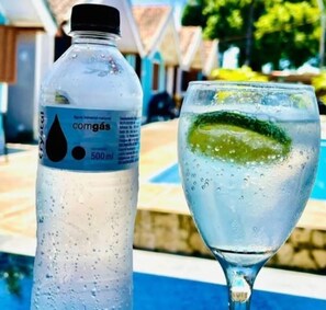 A bottle of Crystal water and a glass with a lime slice.