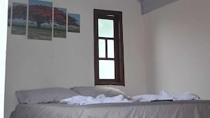 A bedroom with a bed, a ceiling fan, a window, and wall-mounted air conditioning. - Pousada Do Sol (Rio de Janeiro)