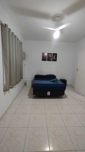 A bedroom with a bed, a ceiling fan, and a wall-mounted air conditioner. - Pousada Do Sol (Rio de Janeiro)