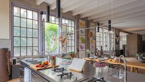 A modern kitchen with a large island, stainless steel appliances, and ample natural light from large windows. - Design Loft With Private Parking by Rent all Como (Como)