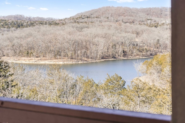 A view of a lake surrounded by trees and hills.