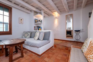 A cozy room with a sofa, a wooden table, and a bookshelf.