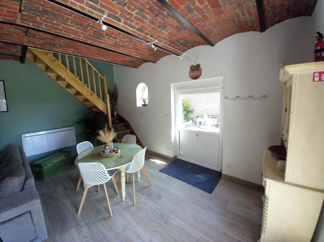 Un espace repas comprenant une table, des chaises et un escalier.