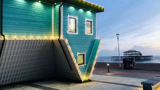 A teal-colored building with a slanted roof, two windows with white frames, and a small balcony. A street lamp and a trash bin are visible in the foreground. - Powis Patio Retreat By My Getaways (Brighton)