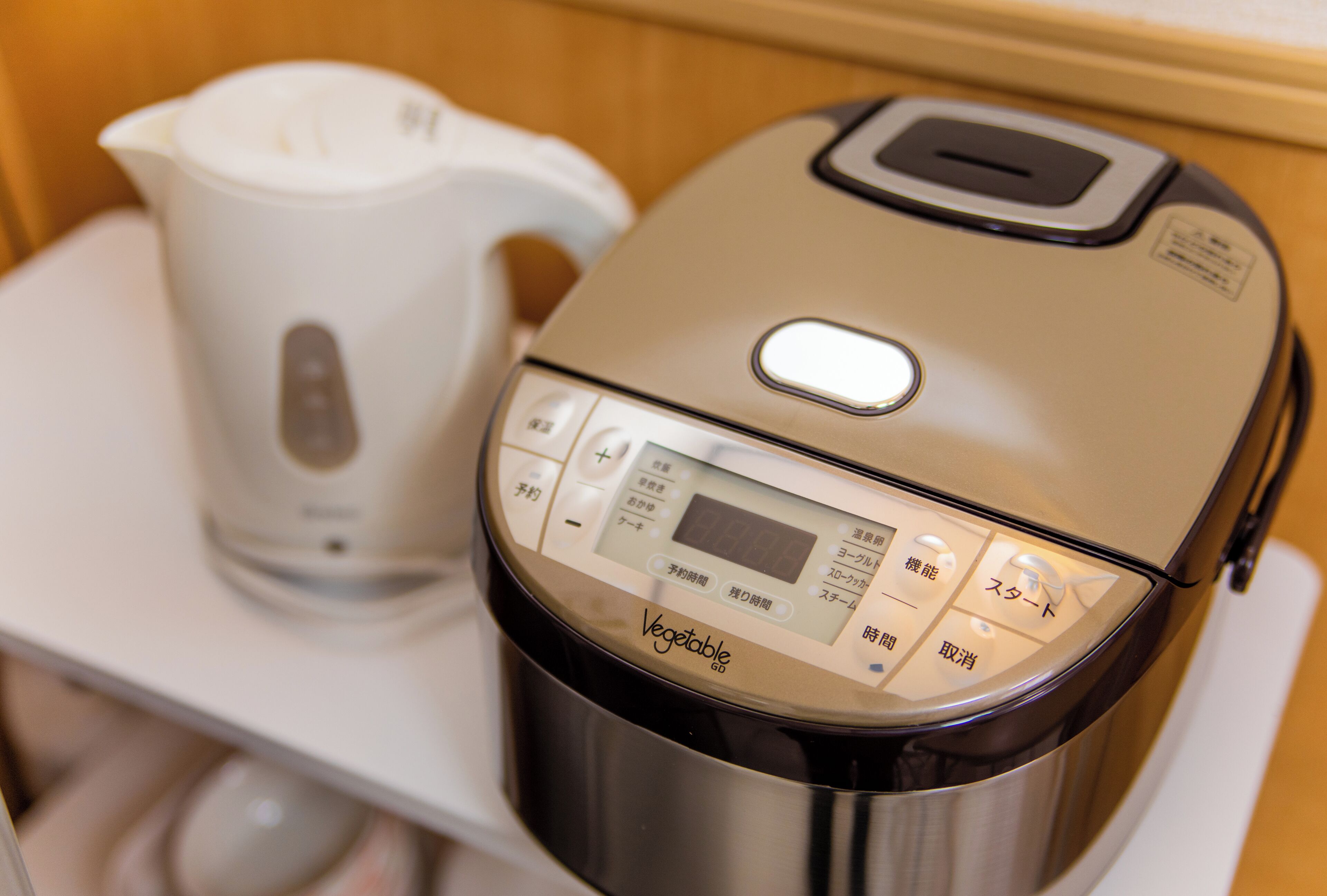 A kitchen with a modern electric kettle and a rice cooker.
