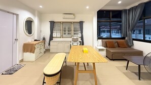 A modern living room with a wooden table, a bench, a sofa, and a window with curtains. - Relaxing Escape in Hua Hin City 94/2 (Tambon Hua Hin)