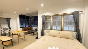 A hotel room with a bed, a desk, a chair, and a sofa. - Relaxing Escape in Hua Hin City 94/2 (Tambon Hua Hin)