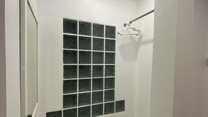 A bathroom with a tiled shower wall, a hanging shower head, and a white sink. - Relaxing Escape in Hua Hin City 94/2 (Tambon Hua Hin)