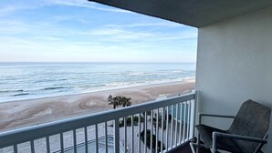 En balkon med udsigt over stranden og havet.