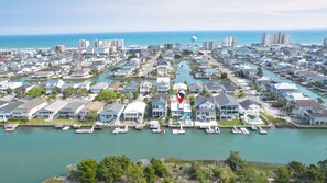 A coastal residential area with houses, docks, and a marina.