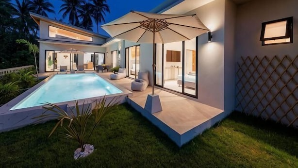 A modern house with a swimming pool, outdoor seating, and a large umbrella. - Sereniwood 2 - 3BR Villa with Private Pool (Koh Samui)
