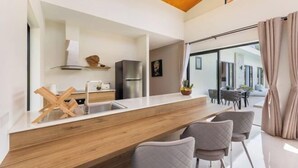 A modern kitchen with a wooden countertop, a built-in sink, and a stainless steel refrigerator. - Sereniwood 2 - 3BR Villa with Private Pool (Koh Samui)